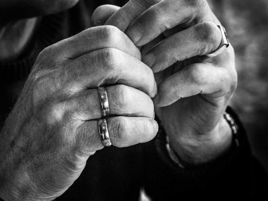 Close-up zwart-witfoto van handen met ringen, in elkaar gevouwen – R-act Fotografie.